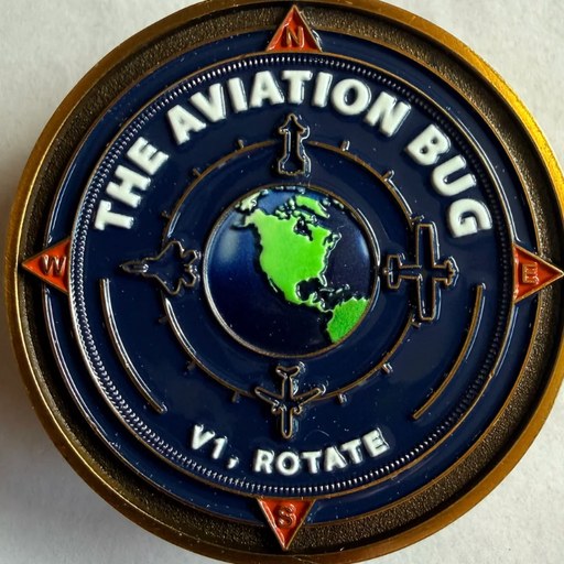 The Aviation Bug challenge coin, front: an enamelled globe and compass rose with V1, ROTATE beneath it